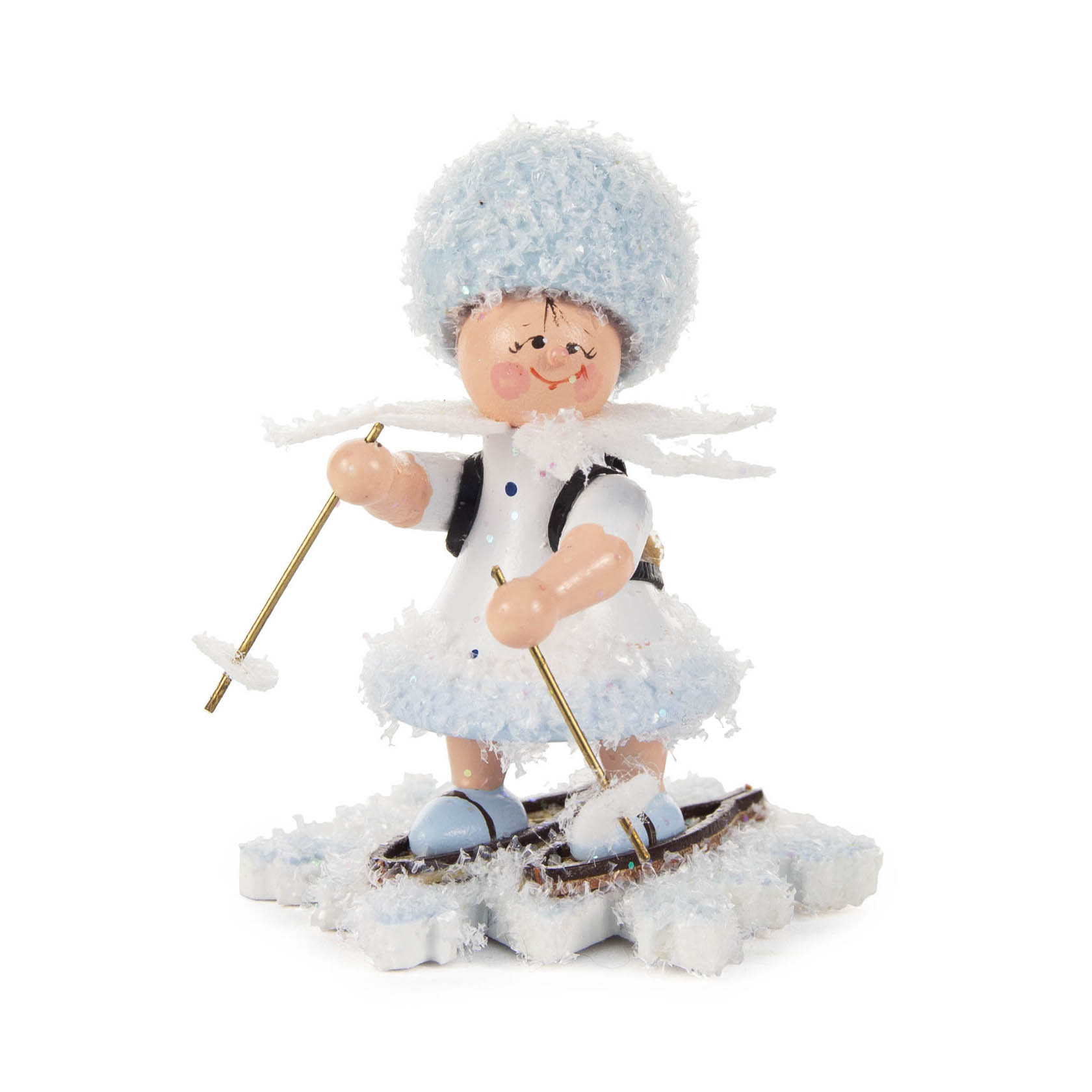 A smiling wooden snow figurine with a fluffy blue hat and coat stands on snowshoes, holding ski poles, representing a snow wanderer. im Dregeno Online Shop günstig kaufen