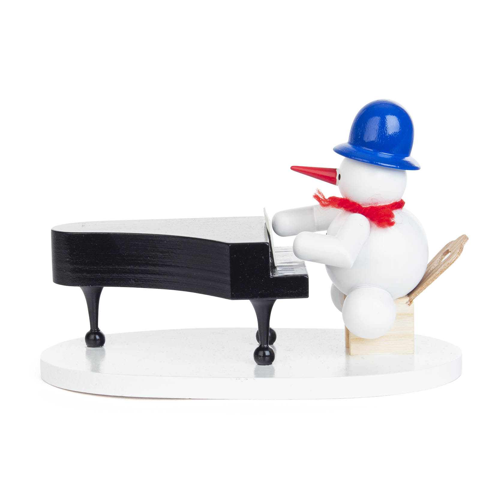 Ein kleiner Schneemann mit blauem Hut und rotem Schal sitzt auf einem Holzstuhl und spielt auf einem schwarzen Flügel.