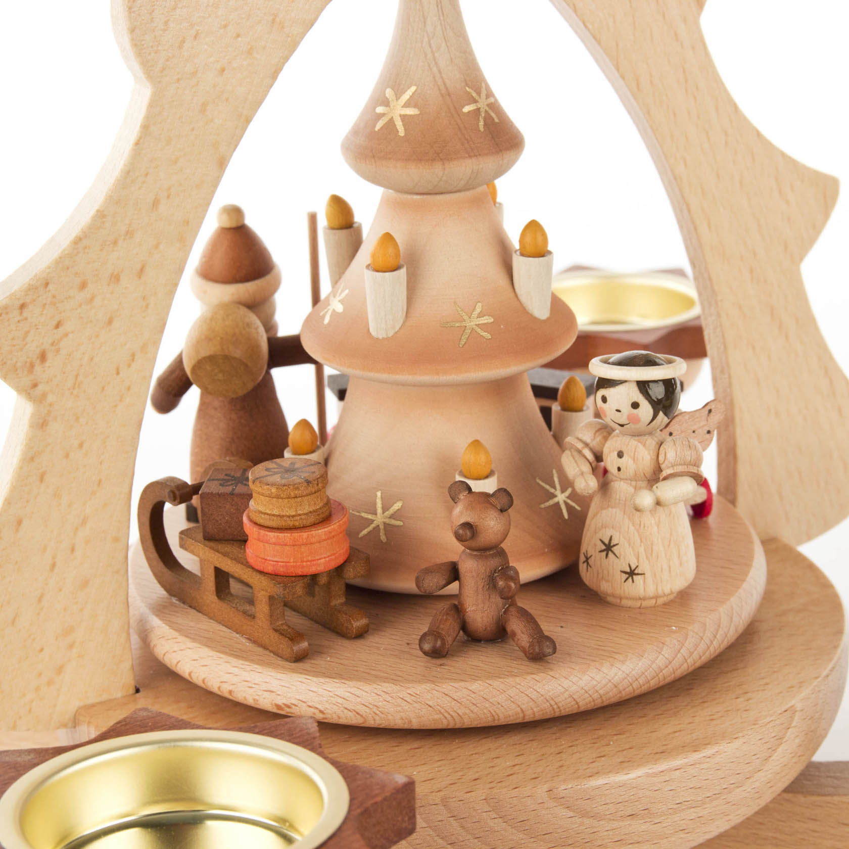 Holzpyramide mit Weihnachtsbaum, Weihnachtsmann, Engel, Eisenbahn und Bärenfigur, um Teelichtschalen gruppiert.