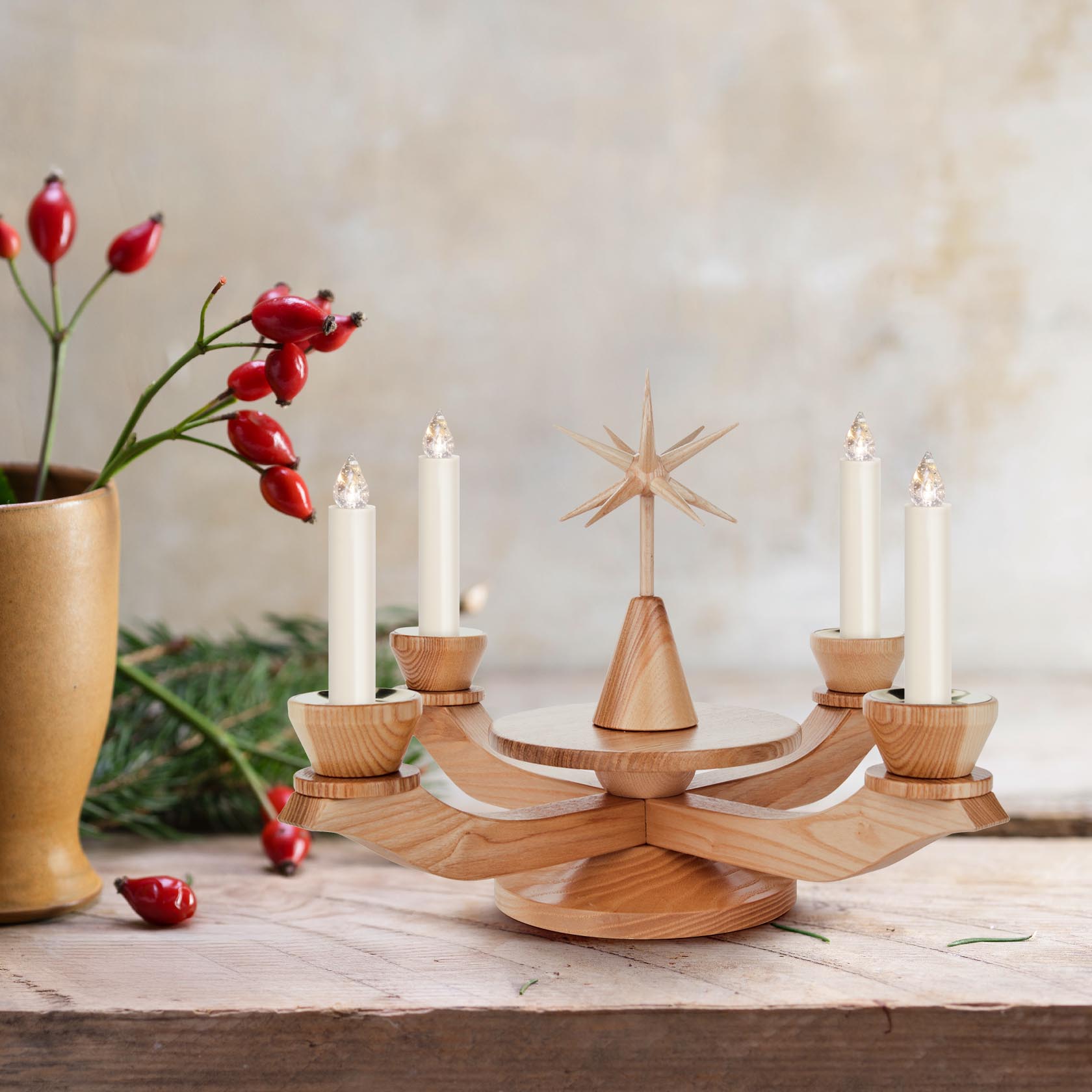Holz-Adventsleuchter mit vier Kerzenhaltern und einem dekorativen Stern in der Mitte, auf einem Holztisch platziert.
