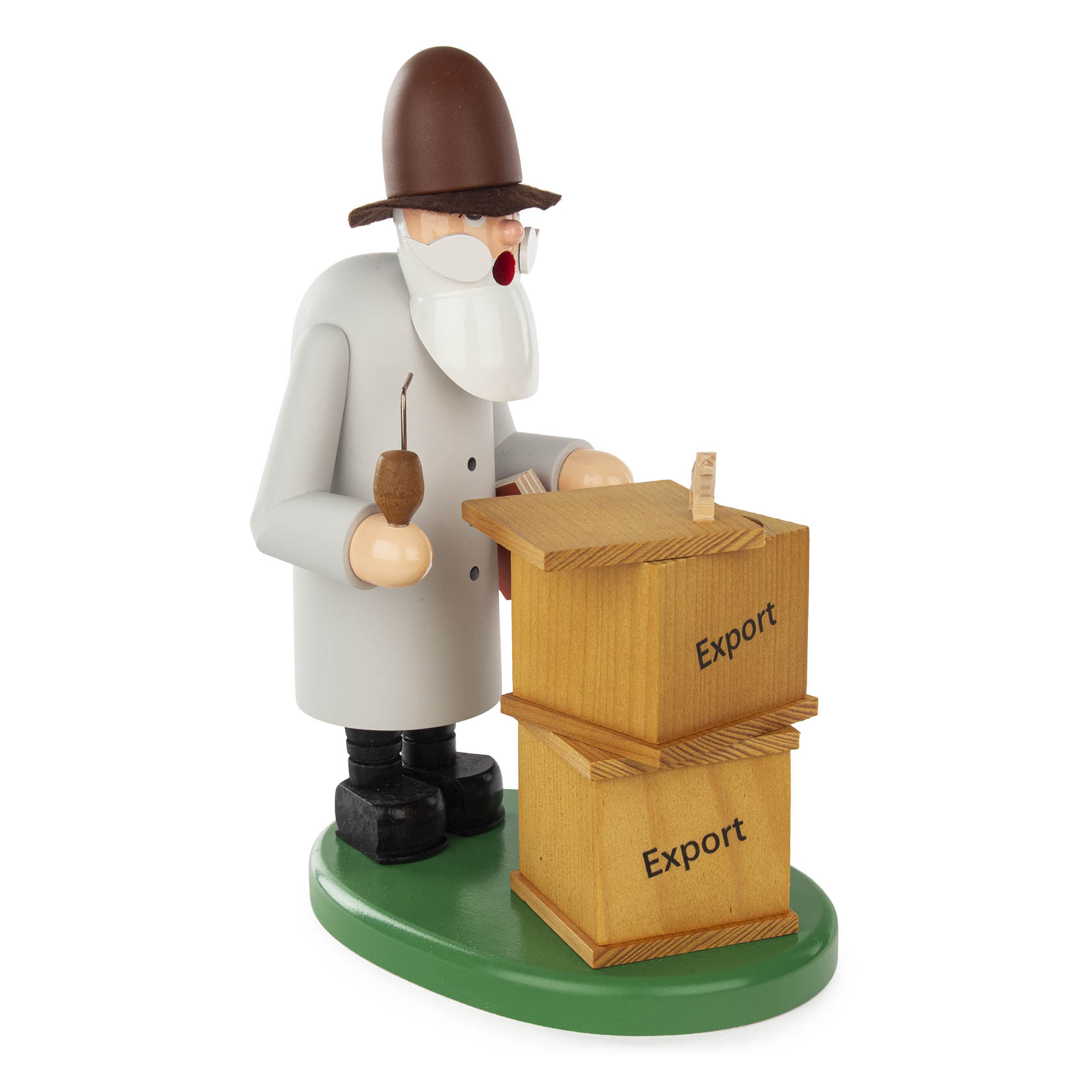 A smoking man figure with a brown hat and beard, holding a pipe and standing beside two 'Export' labeled wooden crates on a green base.
