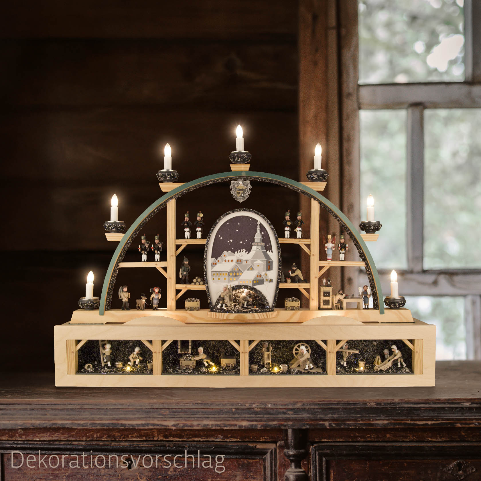 Elektrisch beleuchteter Schwibbogen mit Seiffener Dorf, Bergwerk und Erzgebirgsfiguren auf einem Holzregal, das detailreich ausgestaltet ist.
