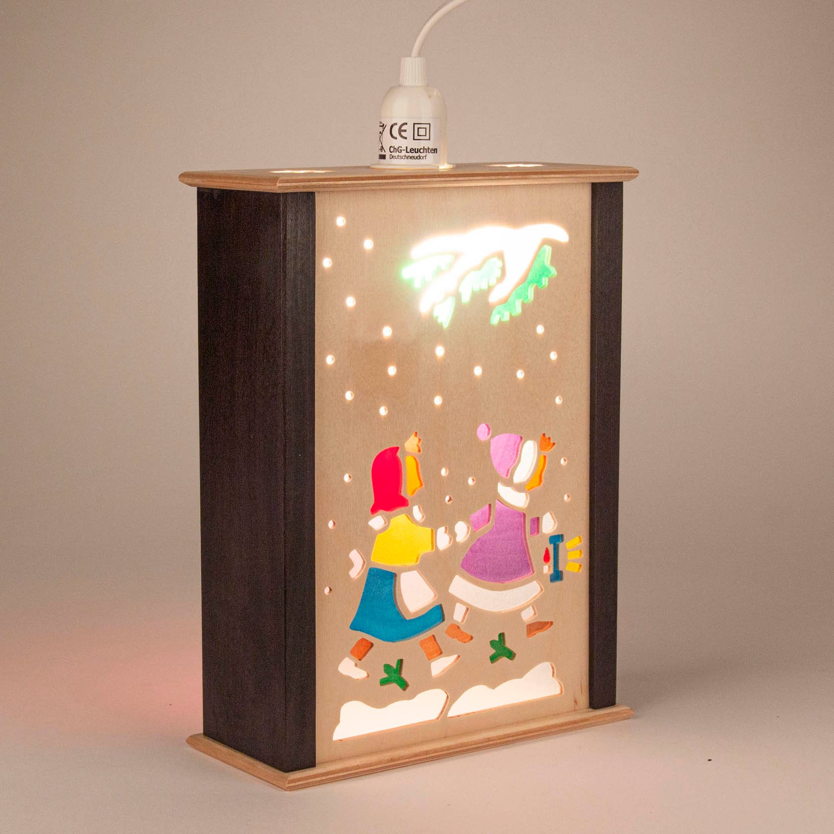 Small children's lantern with a wooden frame, featuring two children in winter clothing walking and carrying a lantern, under a snowy sky.