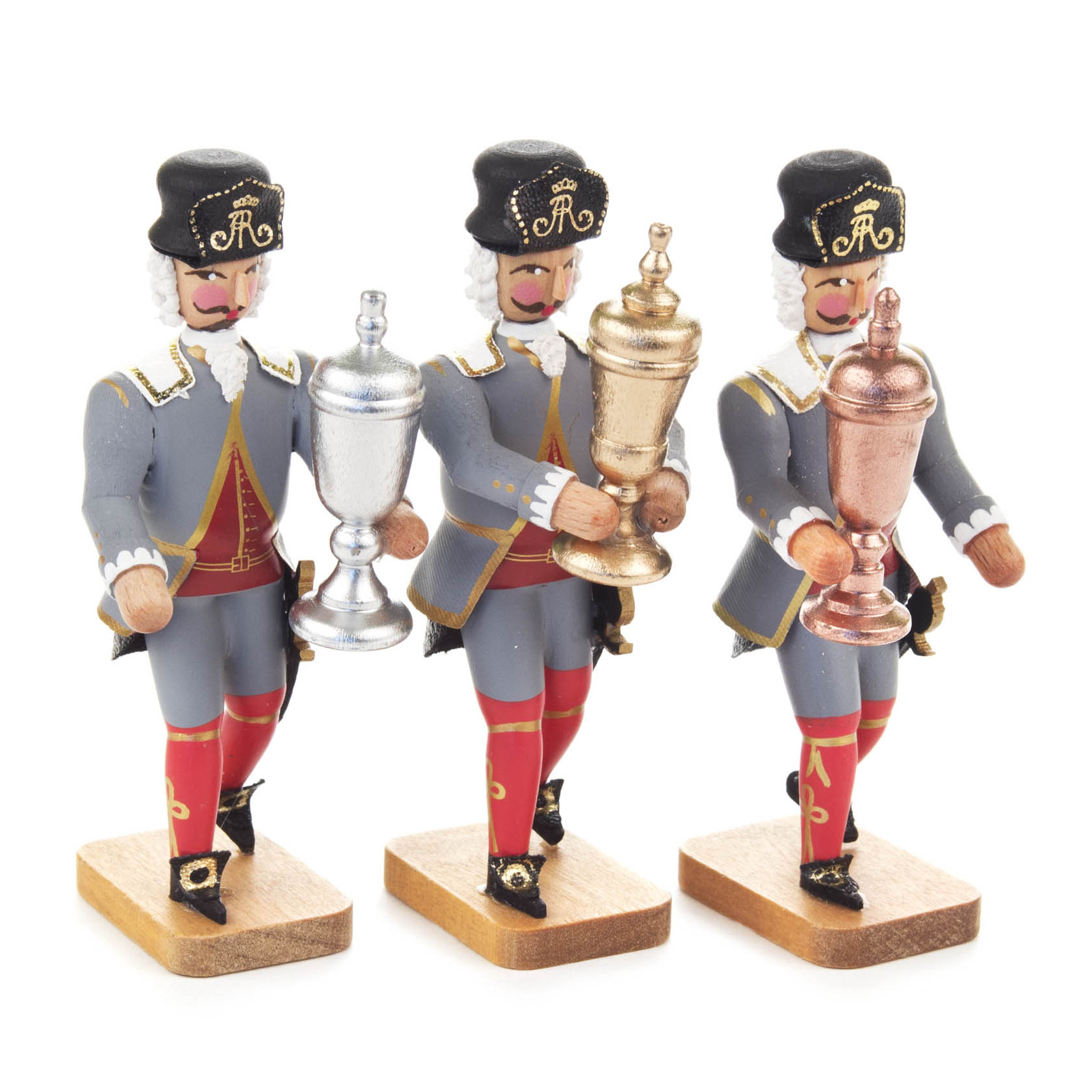Three wooden figurines of baroque miners in uniform, each holding a welcome goblet in silver, gold, and copper colors.