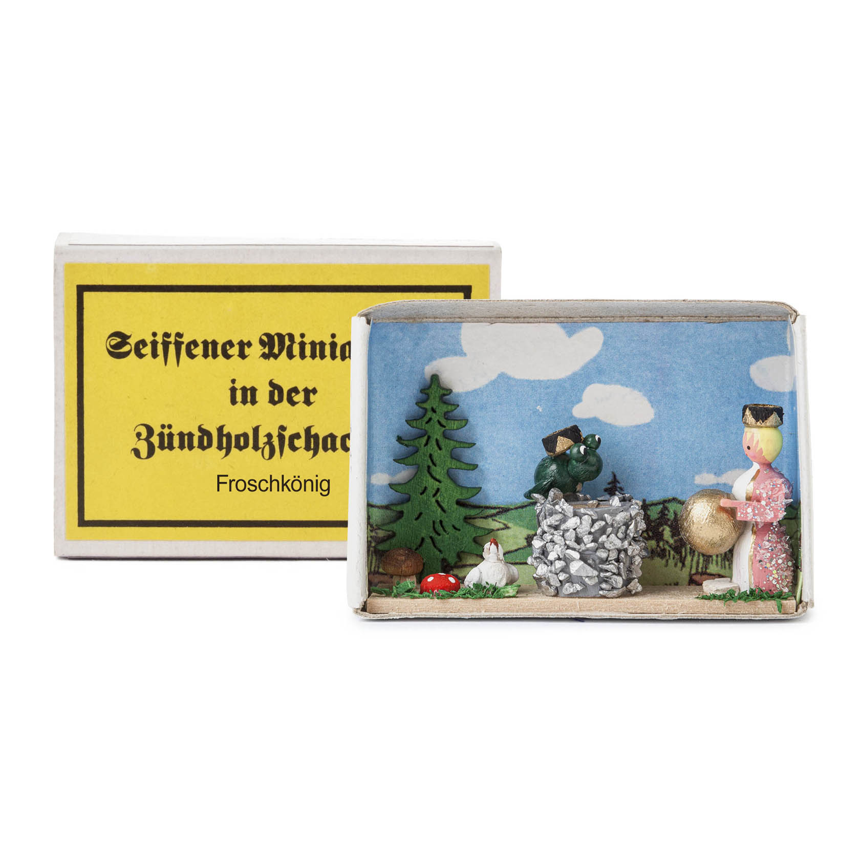 Wooden miniature scene inside a matchbox, depicting the Frog Prince with a green frog and a princess near a stone well and a small tree. im Dregeno Online Shop günstig kaufen