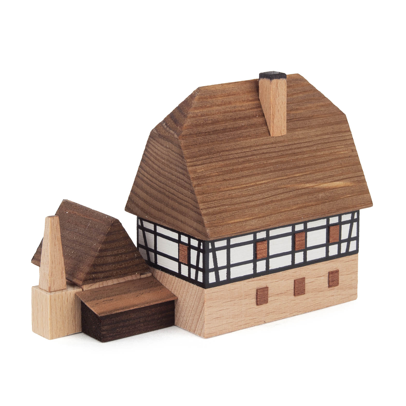 Two-story wooden toy model of a blacksmith shop with an attached annex, featuring a black and white timber-framed design.