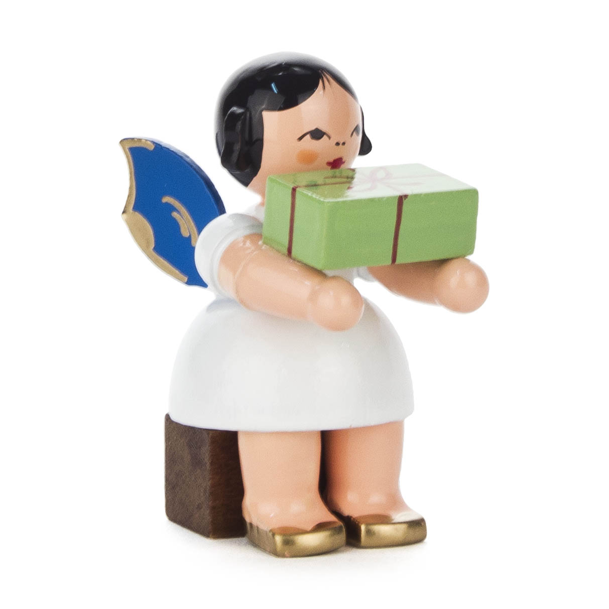 Holzfigur eines Engels in Weiß mit blauen Flügeln. Der Engel sitzt auf einem Holzblock und hält ein grünes Geschenk in den Händen. im Dregeno Online Shop günstig kaufen