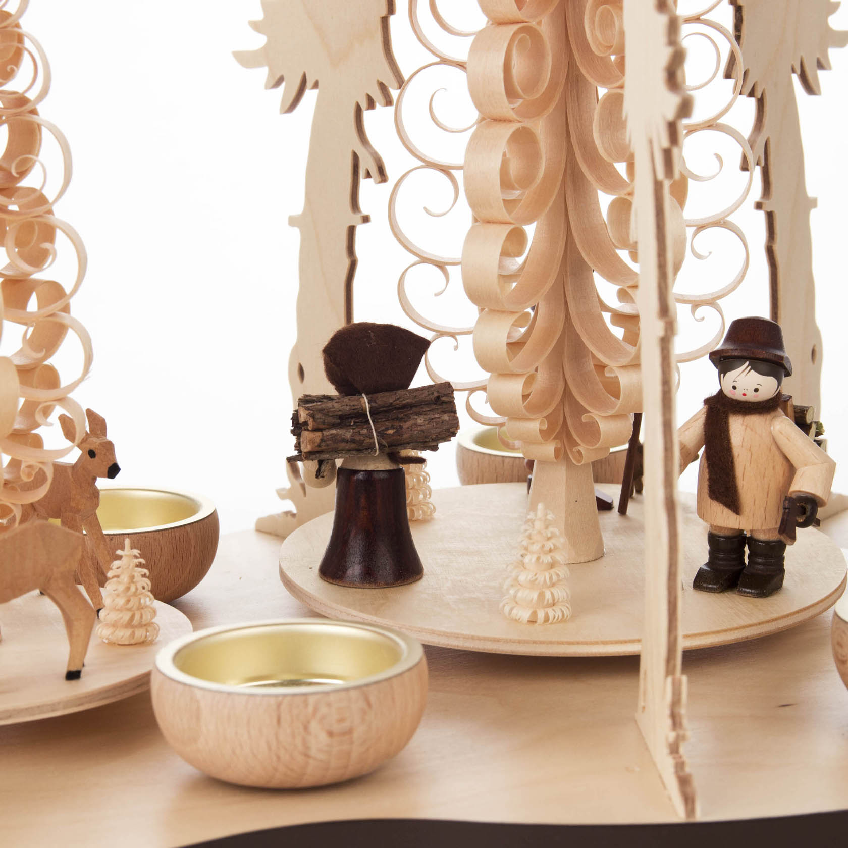 Wooden candle holder with two reindeer and a forest figure holding logs, designed for tea lights. It features intricate, curly wood detailing.