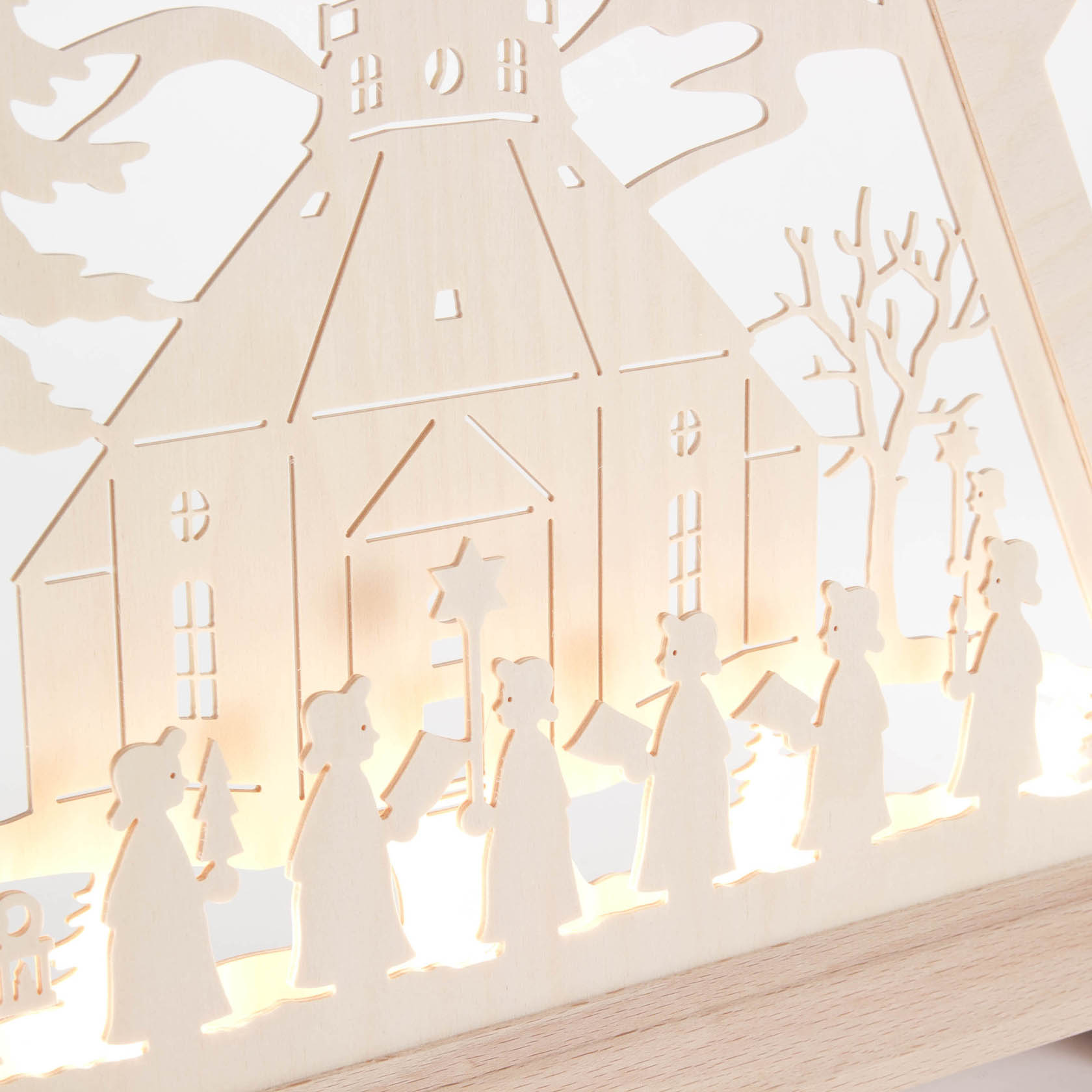 Illuminated wooden Christmas pyramid featuring Seiffen Church and a procession of carol singers holding candles.