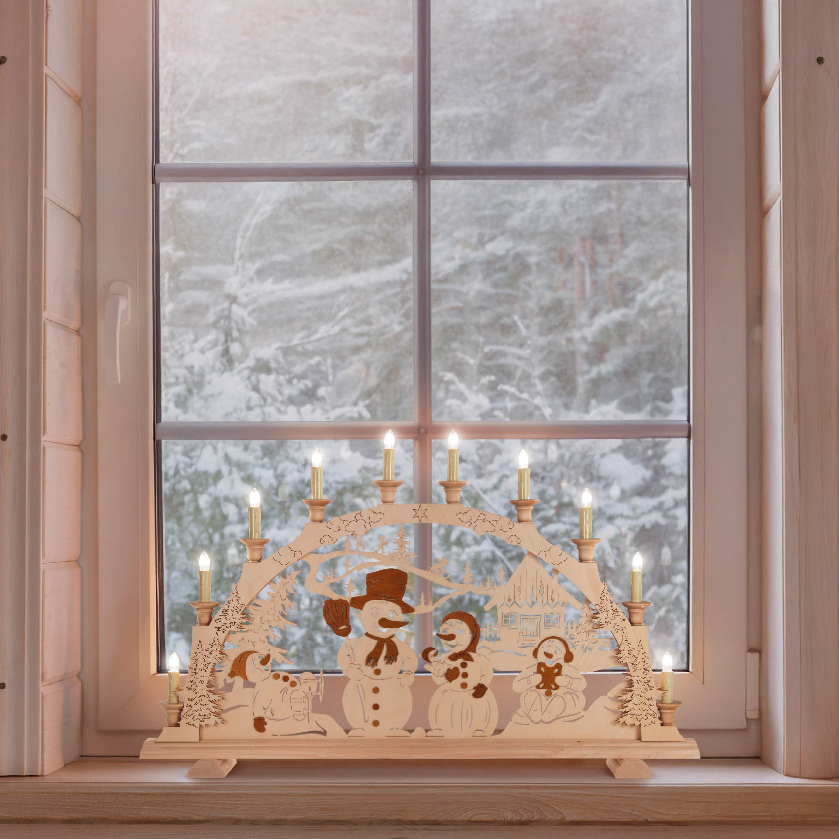 Ein Holz-Schwibbogen mit leuchtenden Kerzen und Figuren von Schneemännern. Der Bogen steht auf einer Fensterbank mit einem verschneiten Hintergrund.