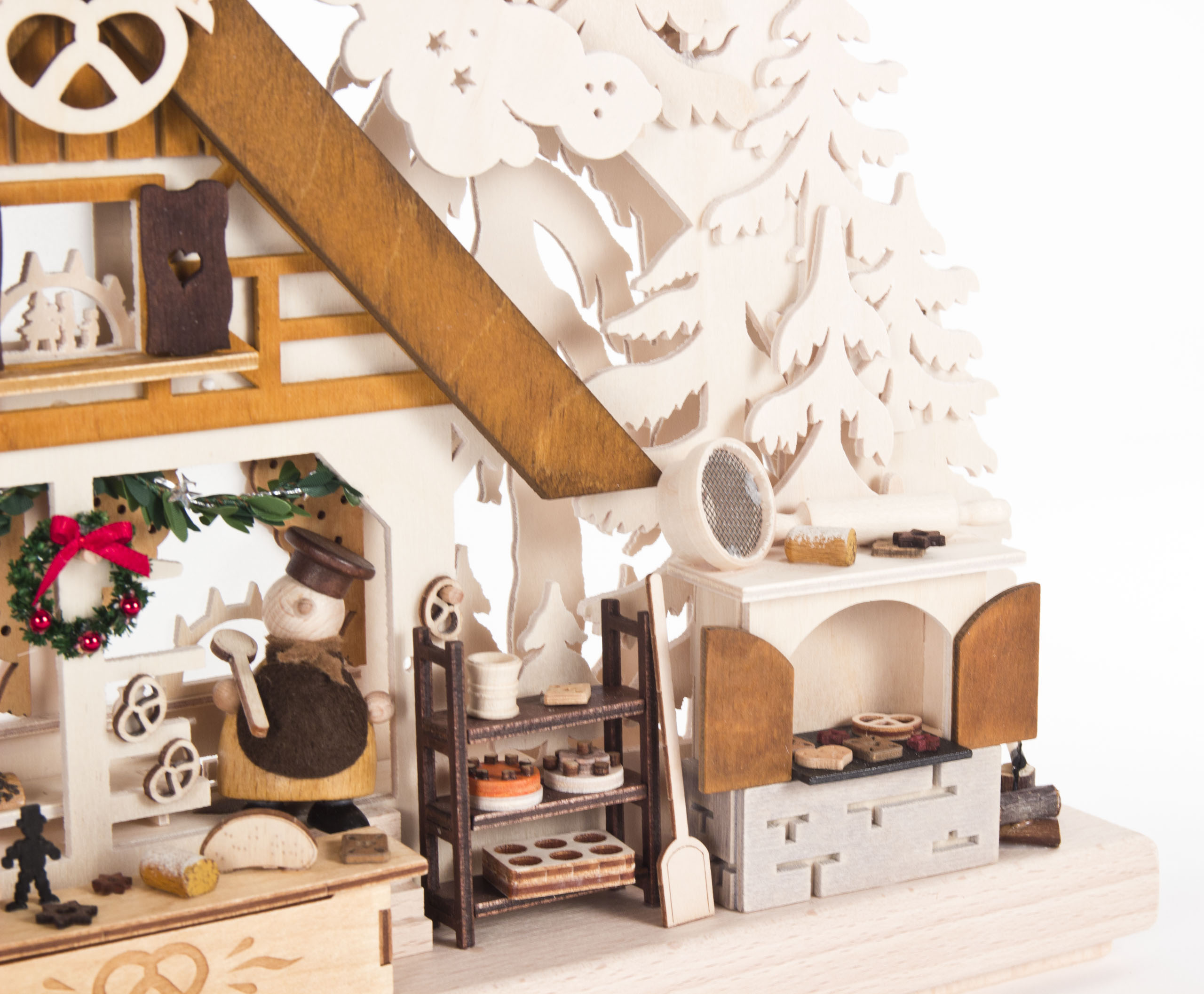 Kleiner Schwibbogen 'Weihnachtsbäckerei' mit indirekter elektrischer Beleuchtung. Zeigt eine Miniatur-Bäckerei-Szene mit Holzdekorationen und winterlichen Motiven.