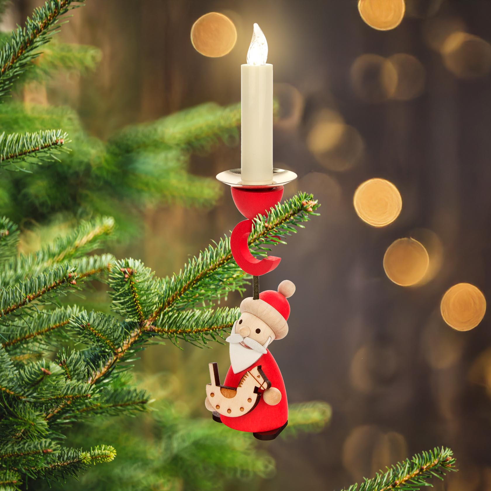 A Christmas tree branch with a candle holder shaped like Santa Claus holding a small rocking horse.
