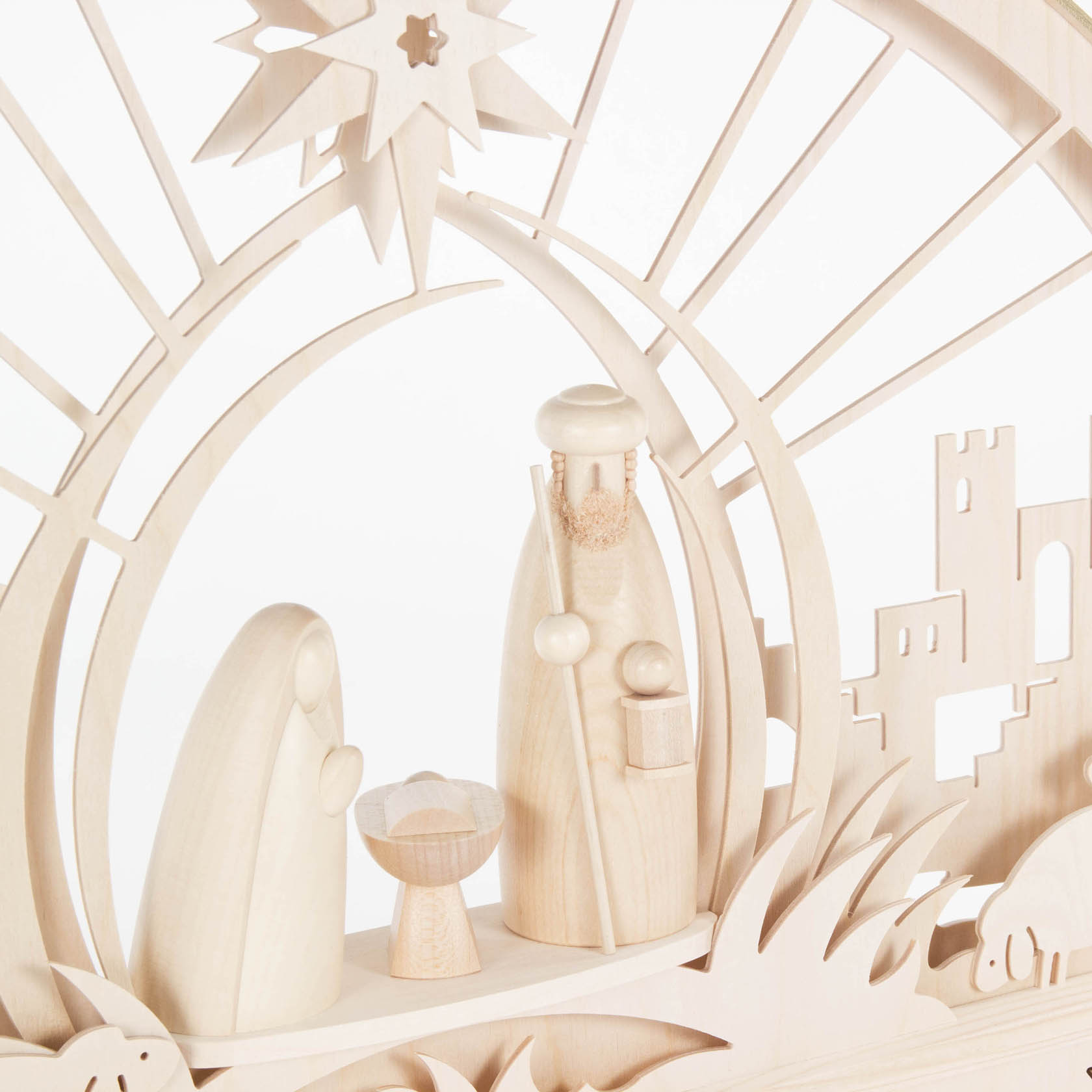 Ein filigraner Schwibbogen aus Holz zeigt die Szene der Geburt Christi mit Maria, Josef und dem Jesuskind in der Krippe, elektrisch beleuchtet.