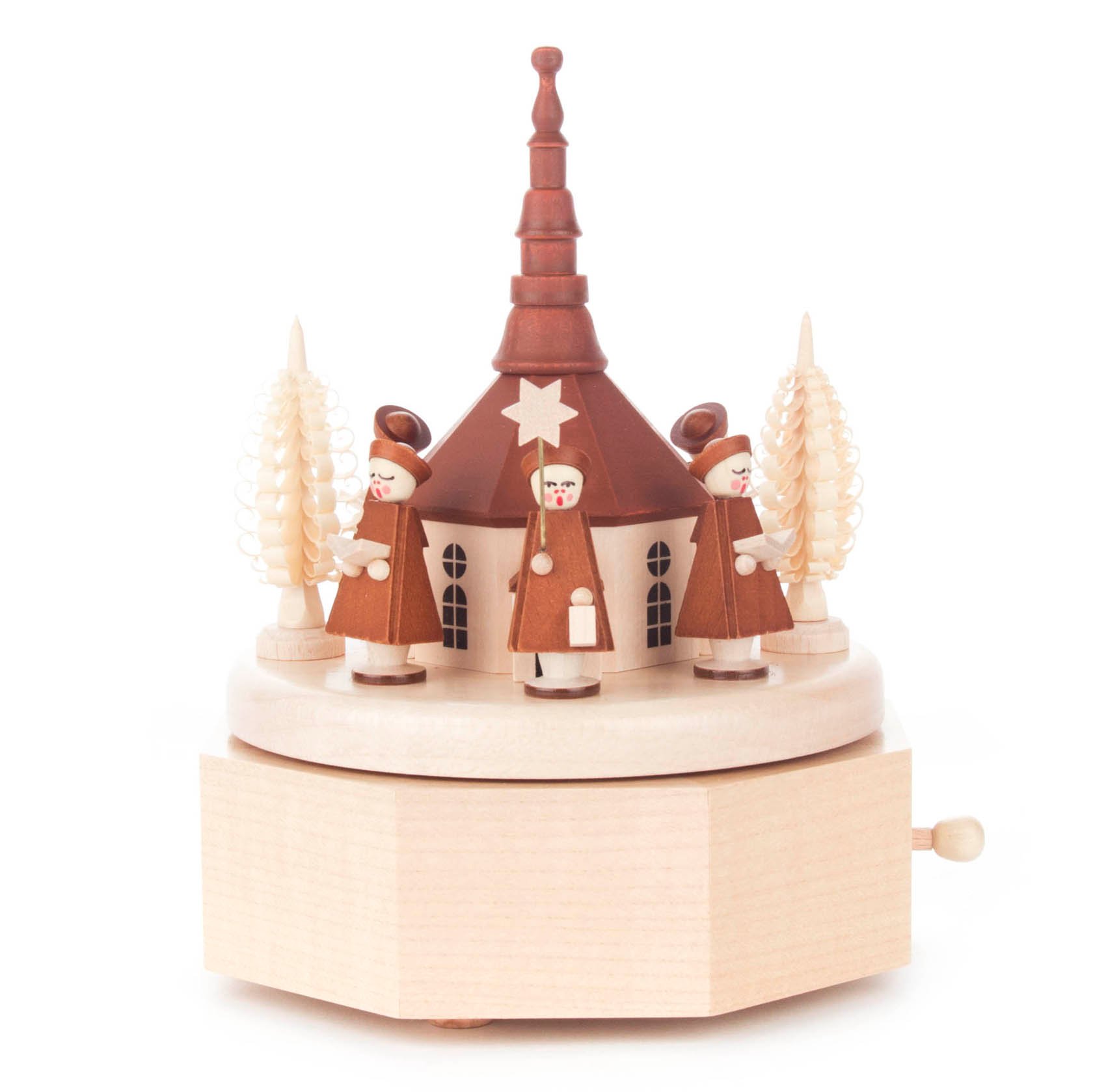 A wooden music box featuring the Seiffen church with three Kurrende singers in brown attire, holding lanterns, surrounded by carved trees.