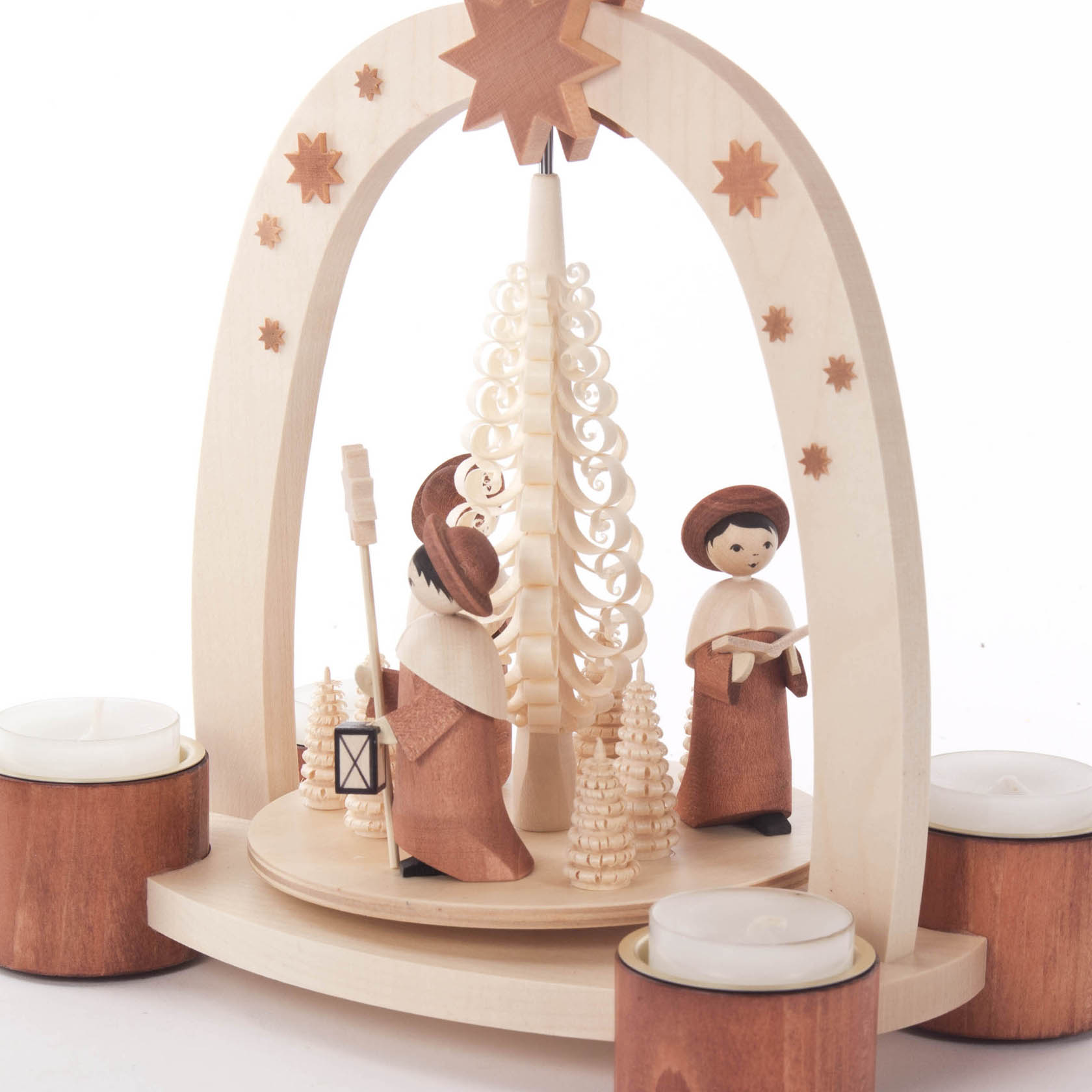 Eine Holzpyramide mit drei Kurrende-Sängern, die Teelichthalter umgeben, ein gedrehter Baum in der Mitte und ein Stern oben.