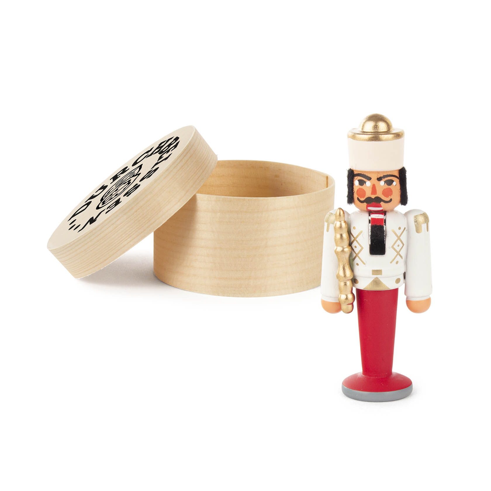 A small nutcracker figurine wearing a white and red uniform with a golden hat and a black beard, next to an open wooden round box.