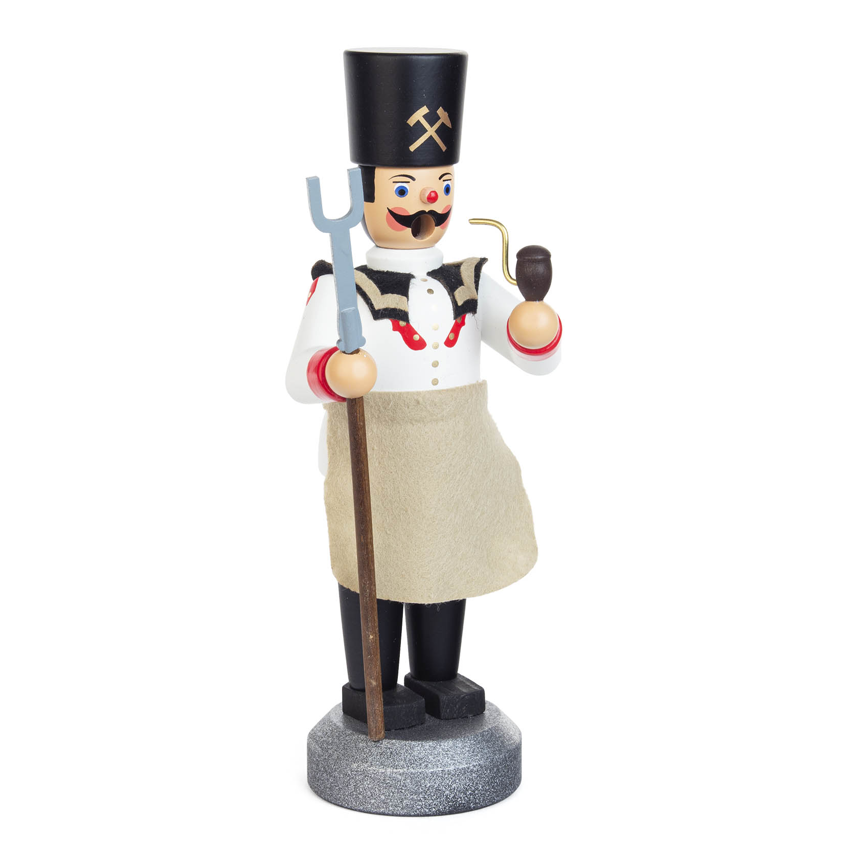 A wooden miner figurine with a black hat featuring crossed hammers, a white shirt, and an apron, holding a pipe and a stick.