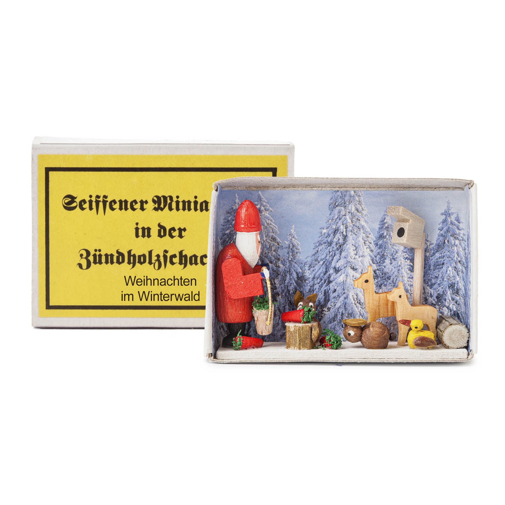 A matchbox diorama featuring a winter forest scene with a small red-robed Santa, wooden deer, trees, and a birdhouse. im Dregeno Online Shop günstig kaufen