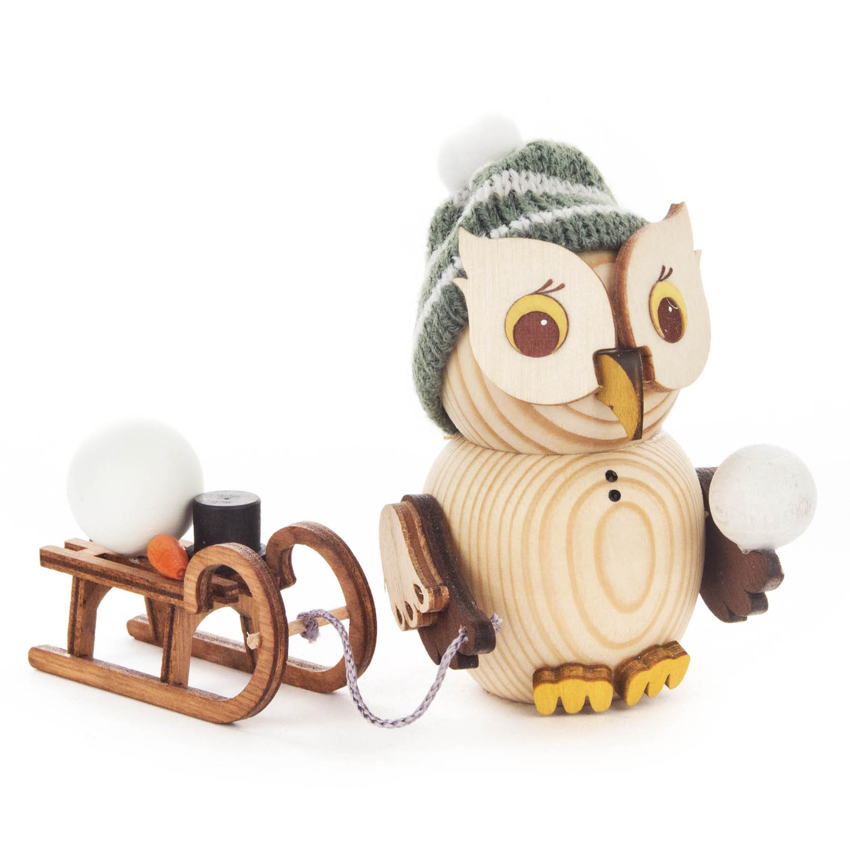 Wooden owl figurine wearing a green knit hat, holding a snowball, and pulling a wooden sled with a small snowman and black item. im Dregeno Online Shop günstig kaufen