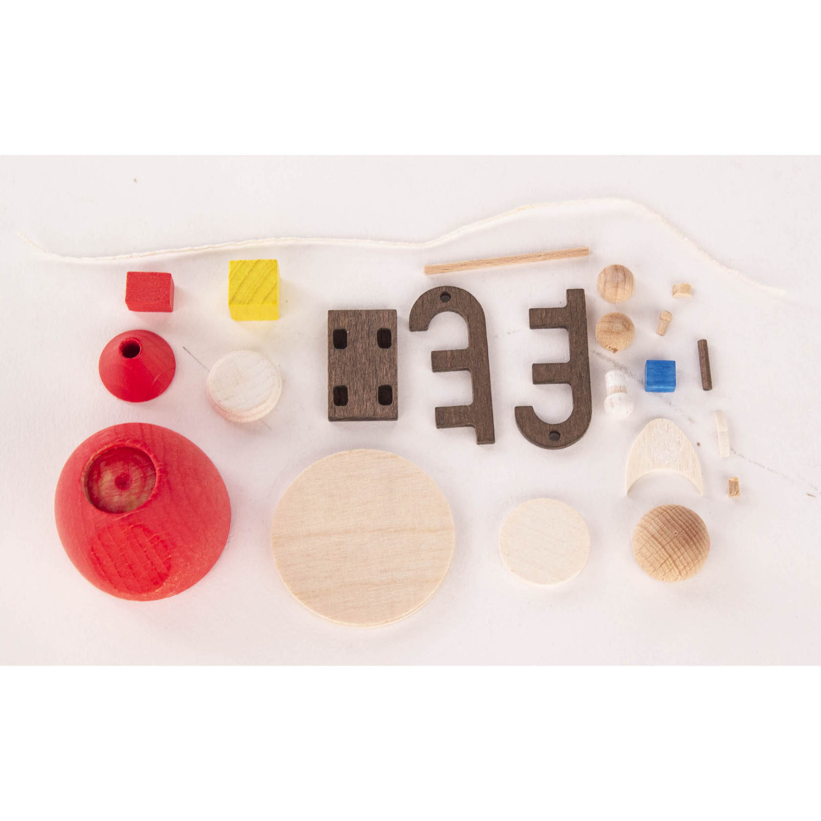 Woodcraft kit pieces for assembling a small Santa Claus and sleigh, including wooden shapes and parts in red, brown, and natural wood colors.