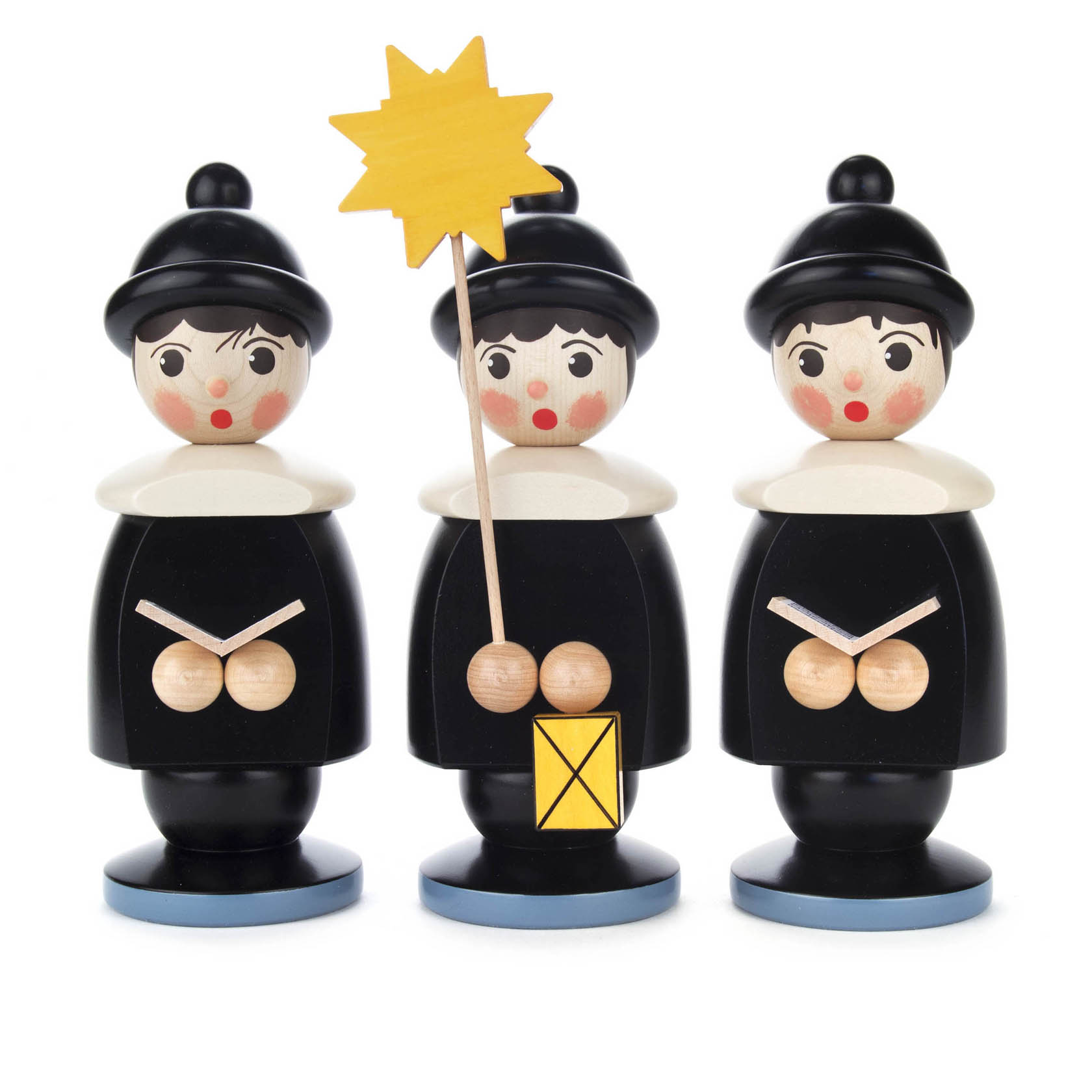 Drei schwarze Kurrendefiguren aus Holz, mit weißem Kragen und Mütze. Die mittlere Figur hält einen gelben Stern und eine Laterne.
