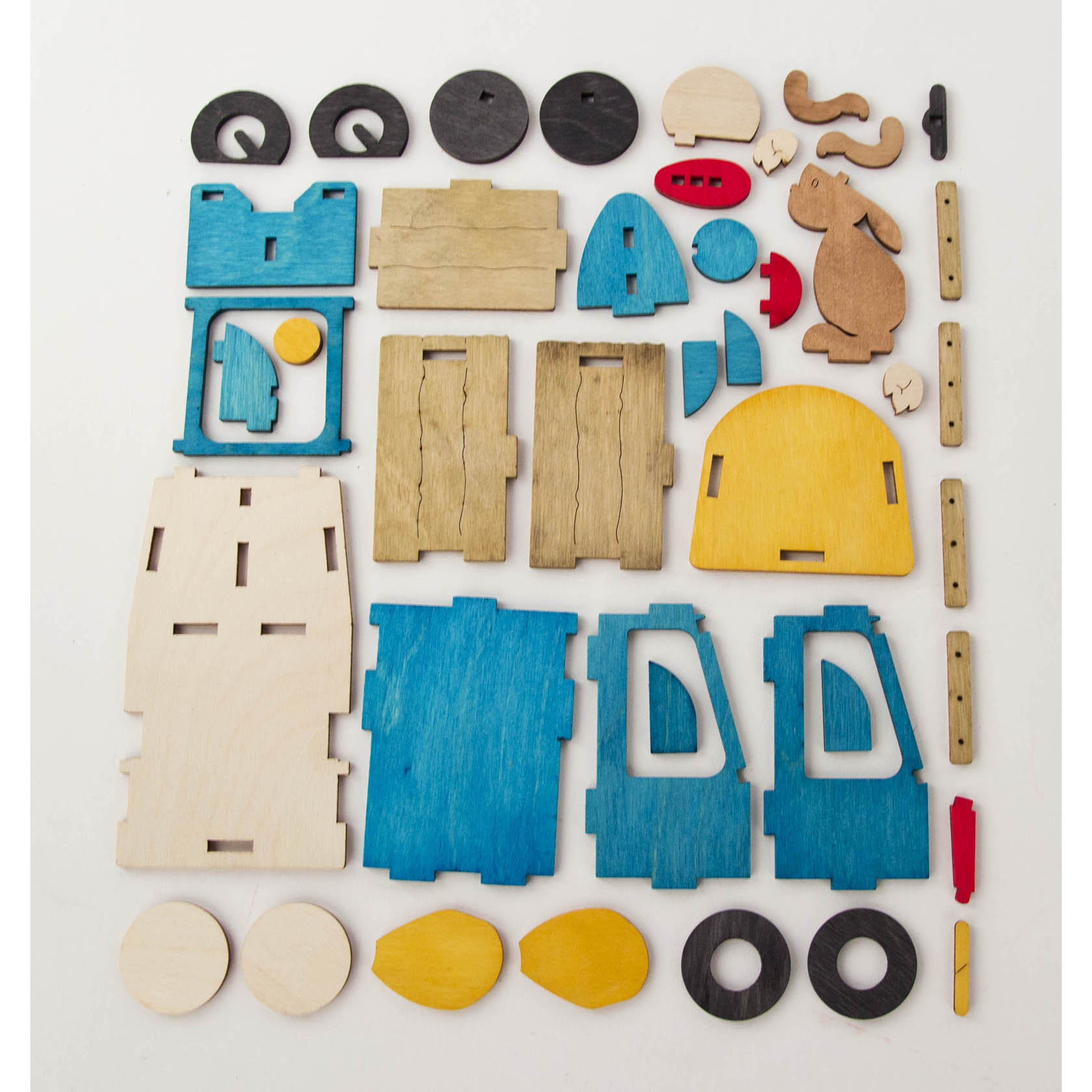 A variety of colorful laser-cut wooden pieces arranged on a flat surface, meant for assembling an Easter-themed express train set.