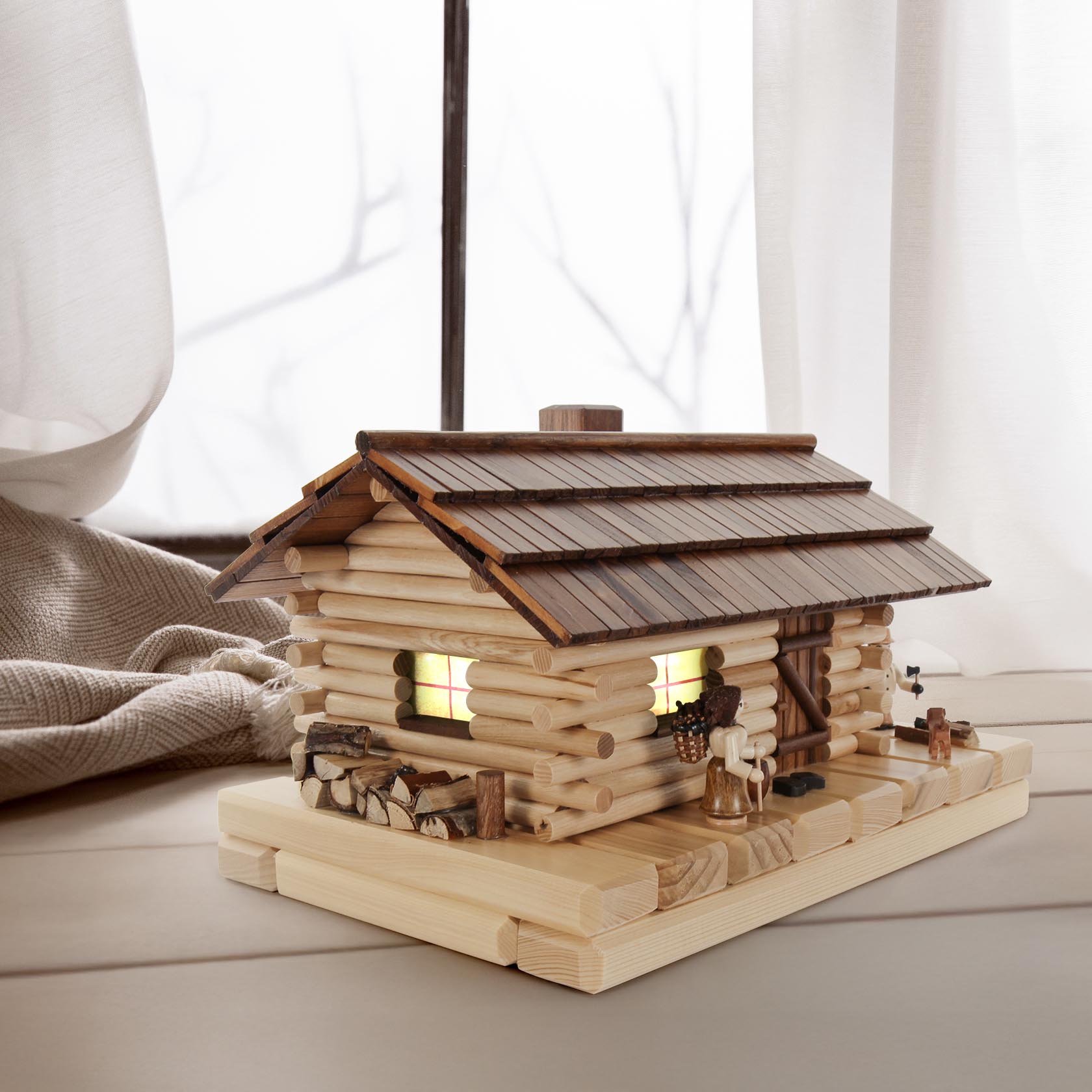 Holzhütte-Dekoration mit elektrischer Innenbeleuchtung und Figuren. Die Hütte aus natürlichen Zweigen dient als Halter für Räucherkerzen zur Erzeugung von Rauch.