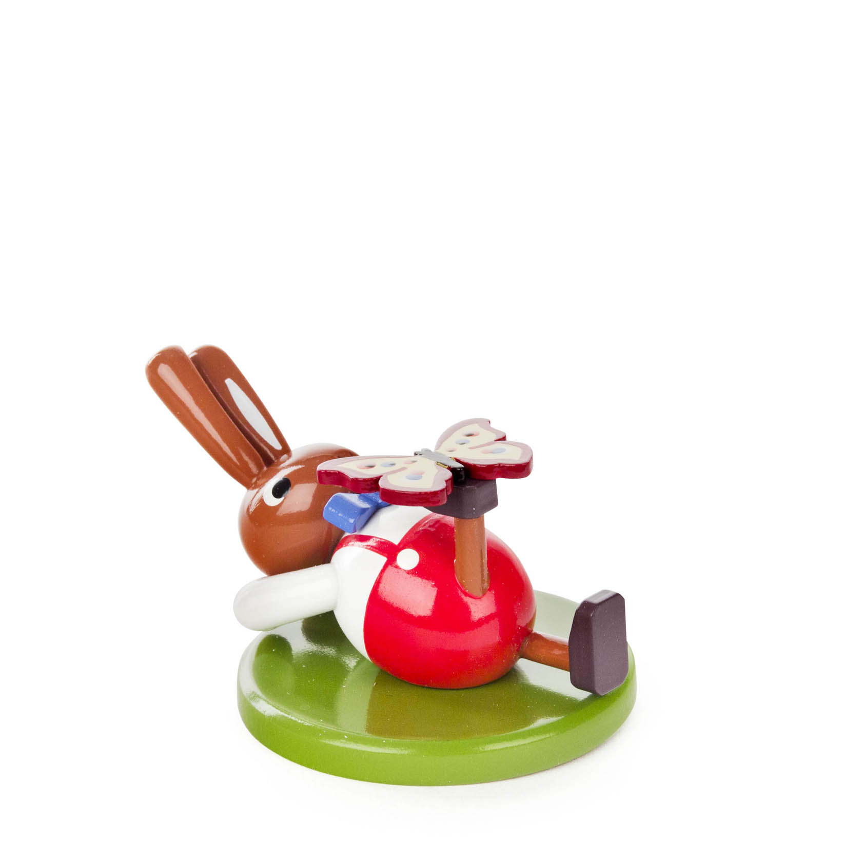 A small, lying down wooden rabbit figurine with a butterfly resting on its belly, all in bright, painted colors.