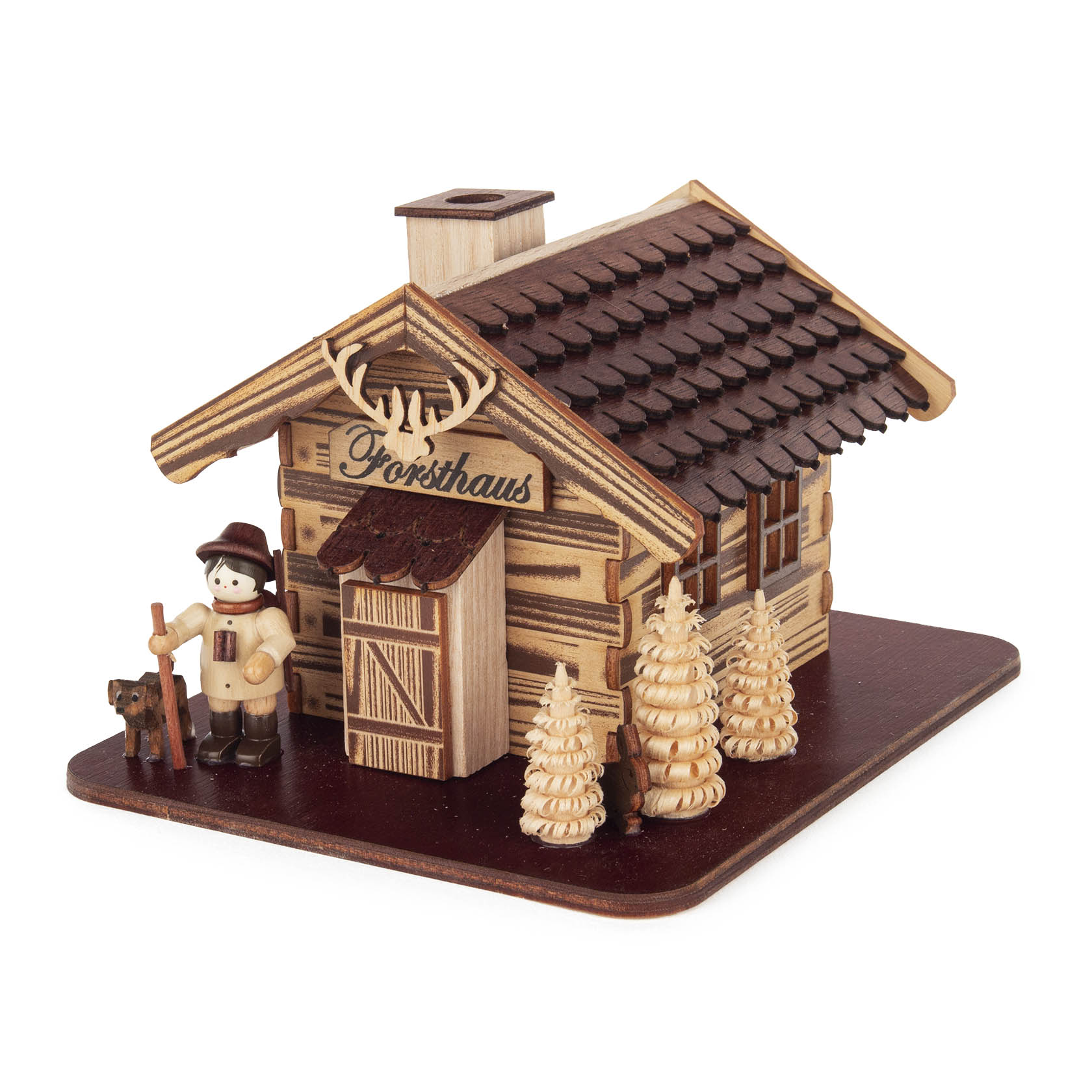 Holzmodell eines Räucherhauses in Form eines Forsthauses mit einem kleinen Jägerfigur daneben. Dach besetzt mit braunen Schindeln und zwei Miniaturräuchertannen davor. im Dregeno Online Shop günstig kaufen