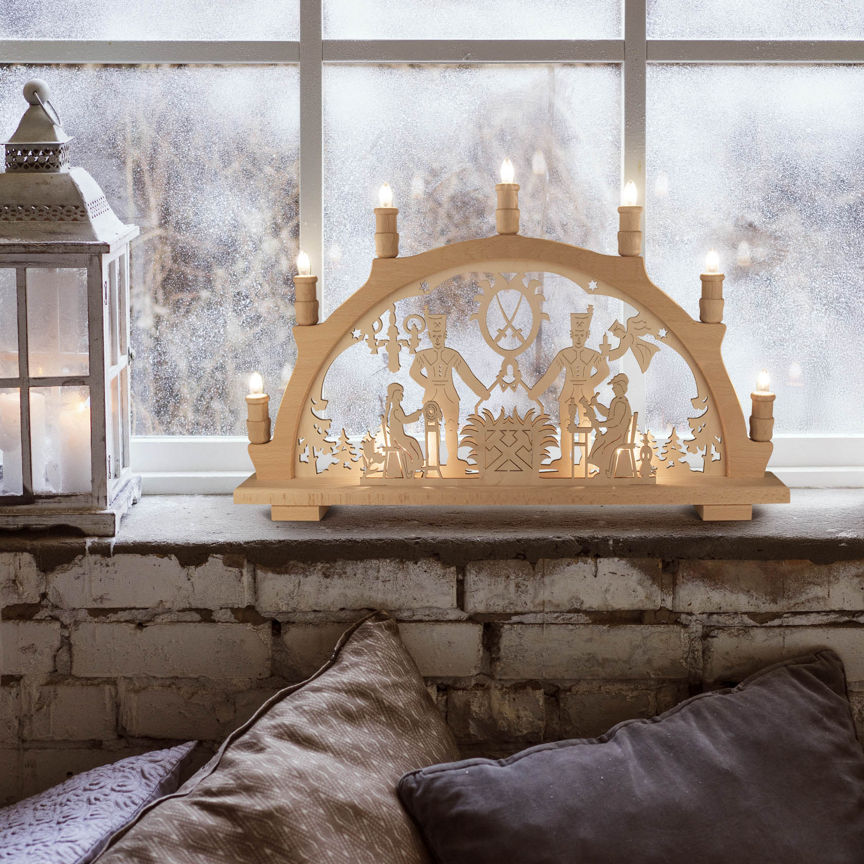 An electric illuminated wooden arch with carved figures of miners and trees, sitting on a windowsill. Traditional Schwibbogen with eight small lights.