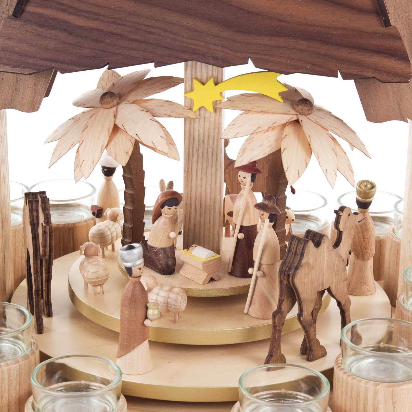 Wooden pyramid depicting the Nativity scene with Mary, Joseph, baby Jesus, shepherds, and animals. Two large wooden flowers on top, designed for tea lights.