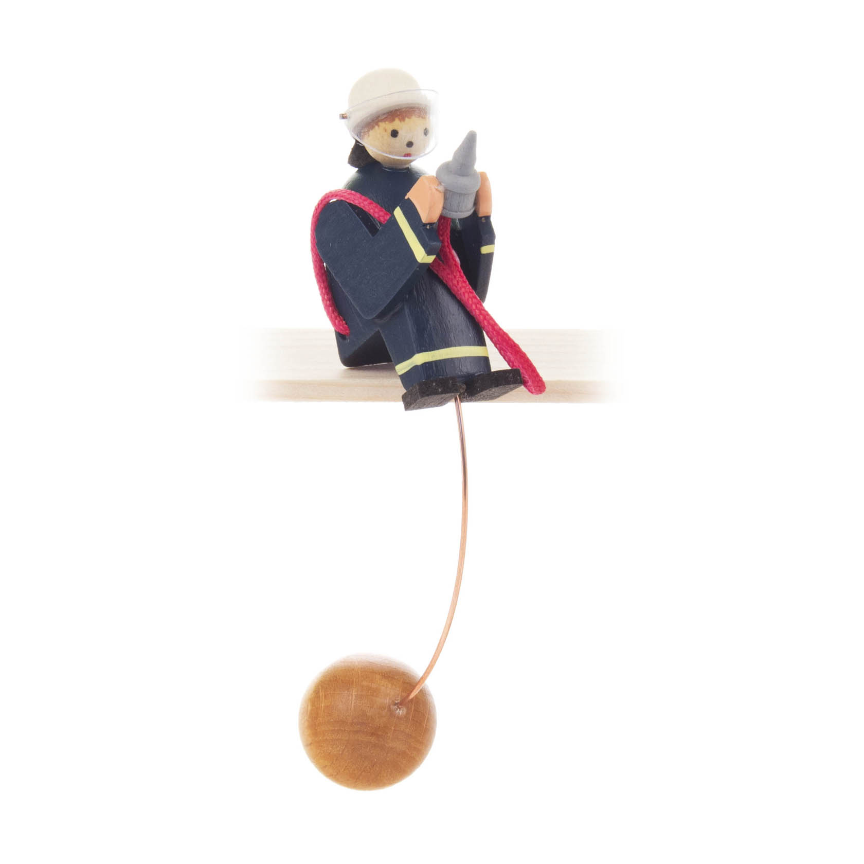 Holzfigur eines Feuerwehrmannes in blauer Uniform und rotem Schlauch balanciert auf dünnem Metallstab, der mit einem Holzball befestigt ist. im Dregeno Online Shop günstig kaufen