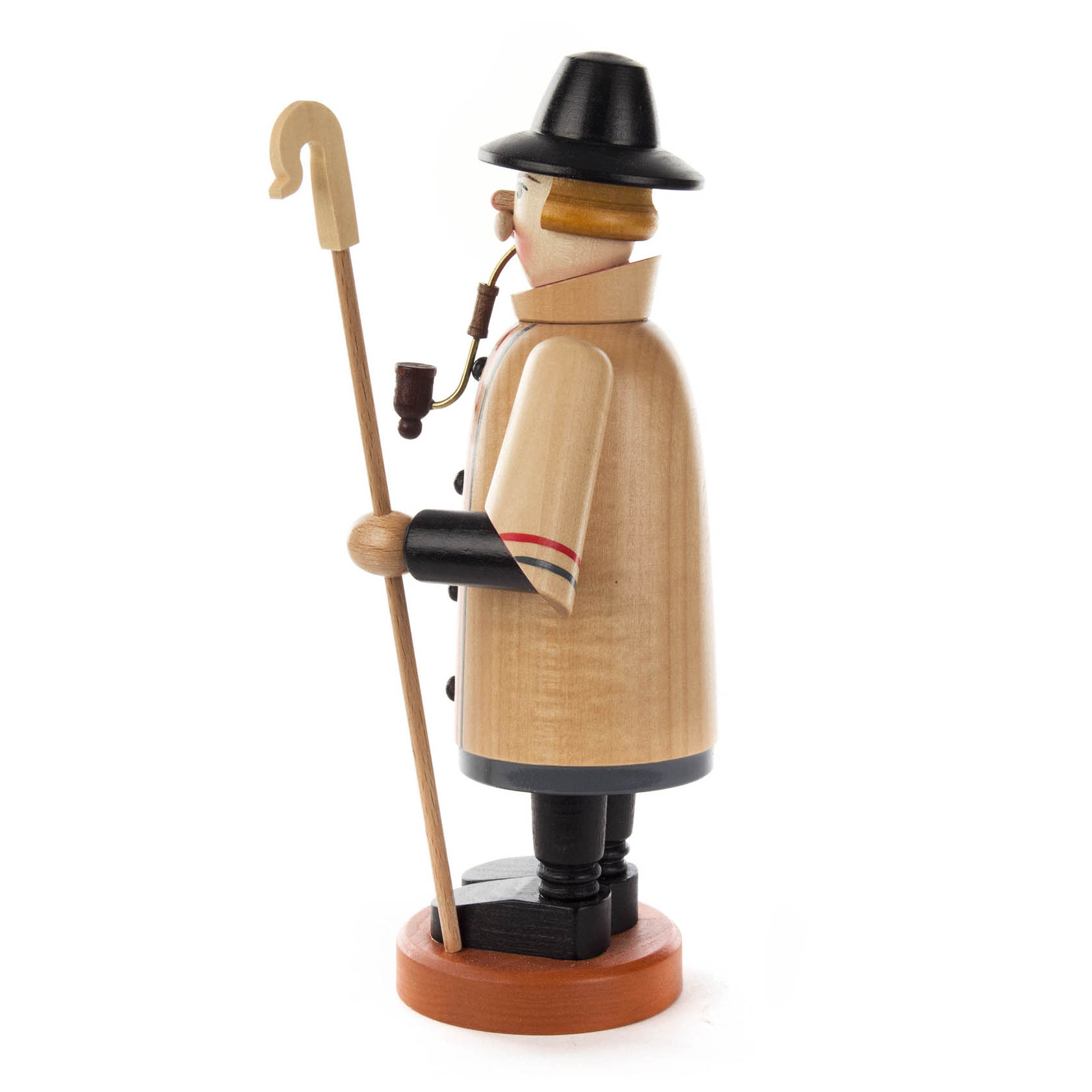 Holzfigur eines Schäfers mit Pfeife, schwarzem Hut und Stab, trägt einen beigen Mantel und schwarze Stiefel.