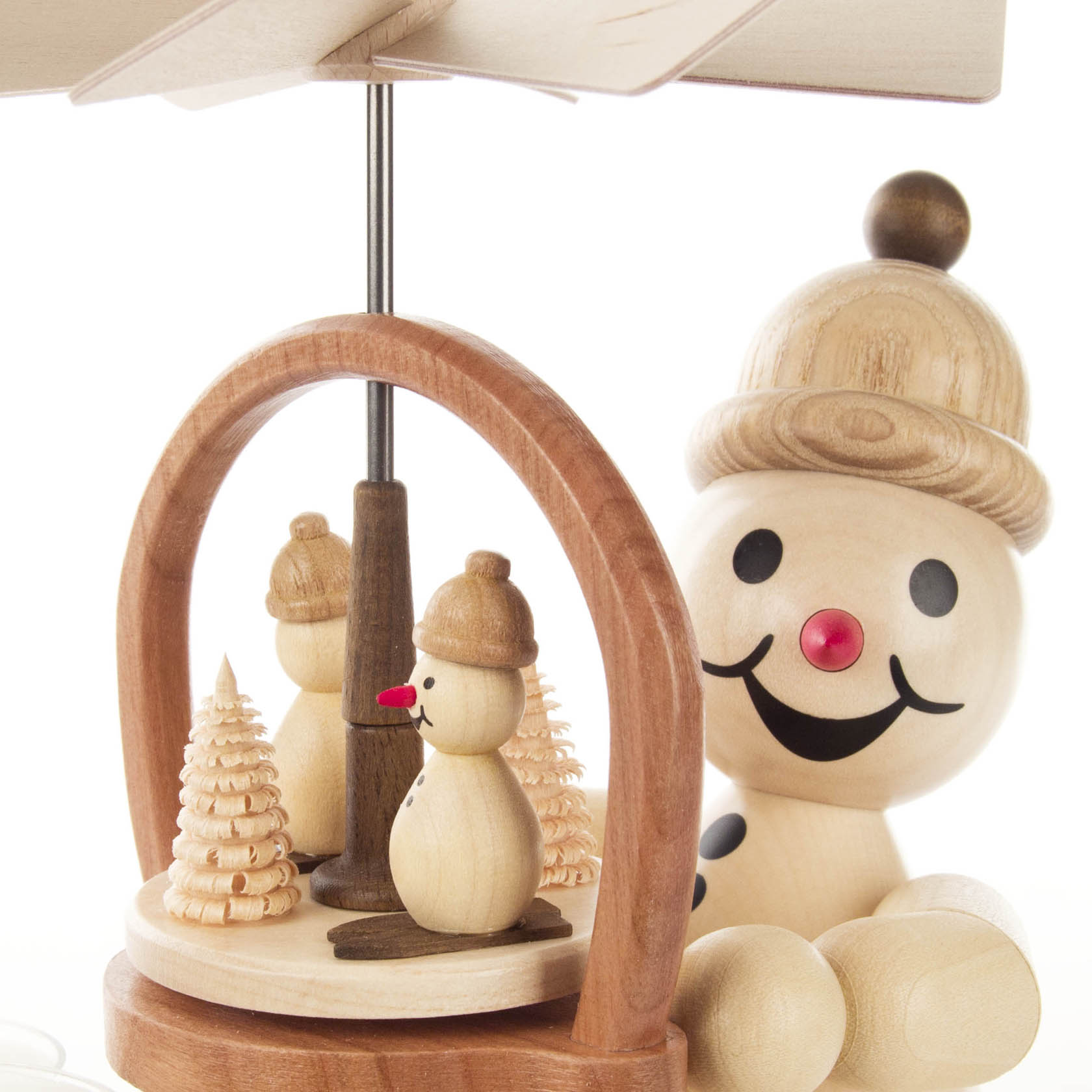Holzpyramide mit einem weißen Schneemann mit brauner Mütze und roten Details, neben kleinen Holzfiguren und Bäumen.
