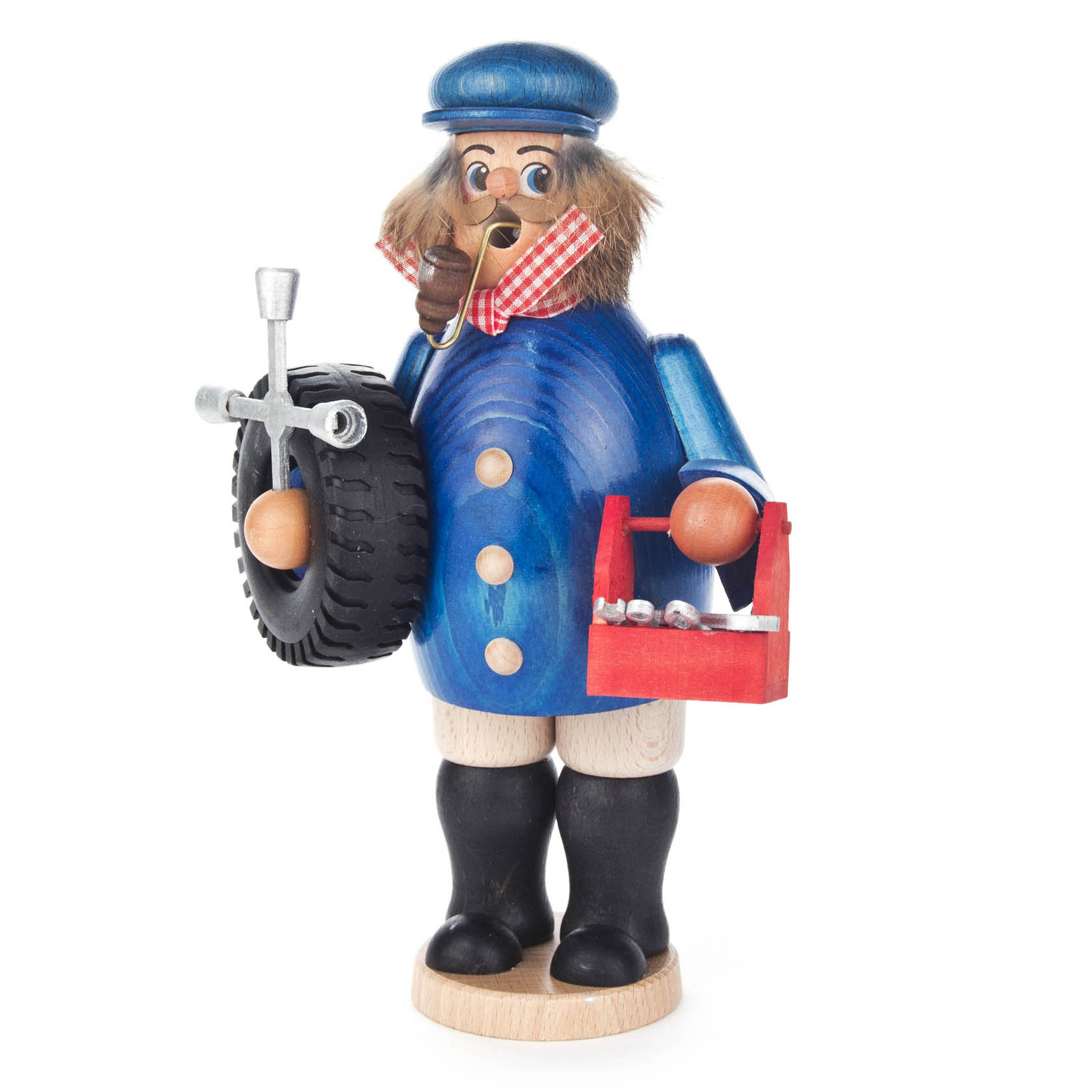 A figurine of a mechanic made of wood, wearing a blue coat and cap, holding a tire and a red toolbox, with a pipe in its mouth.